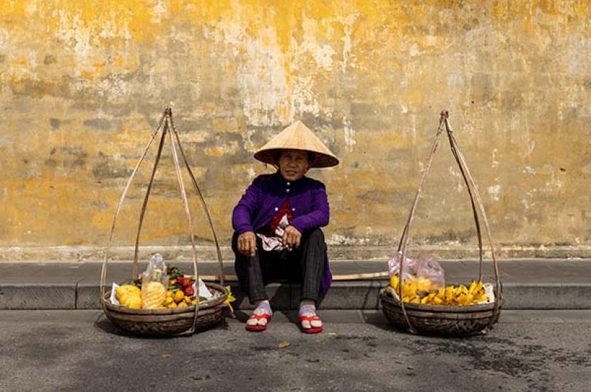 A fruit seller in the streets of Hoi An, where Just You’s Discover Vietnam itinerary visits community projects