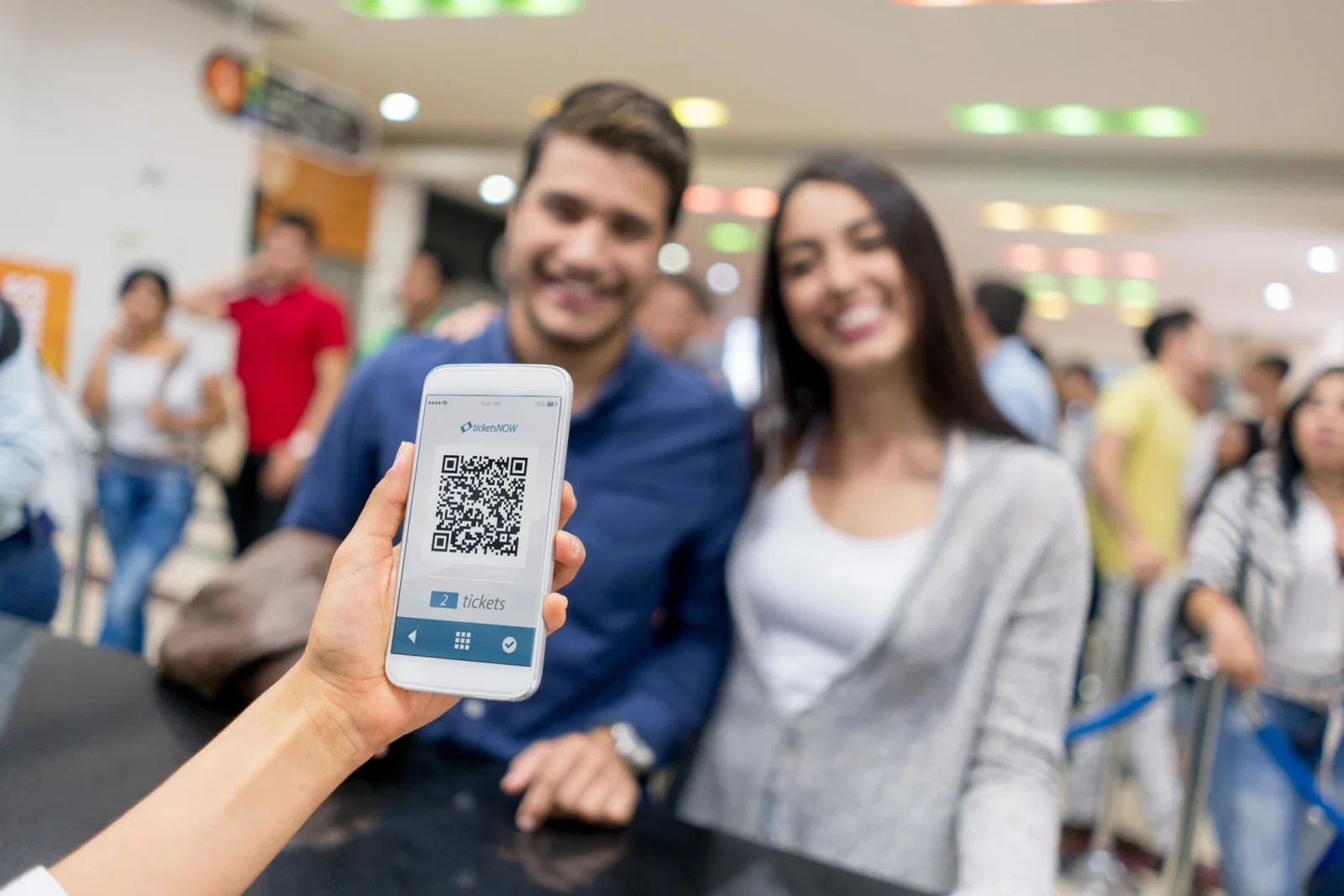 Two people present a QR code to get into an event