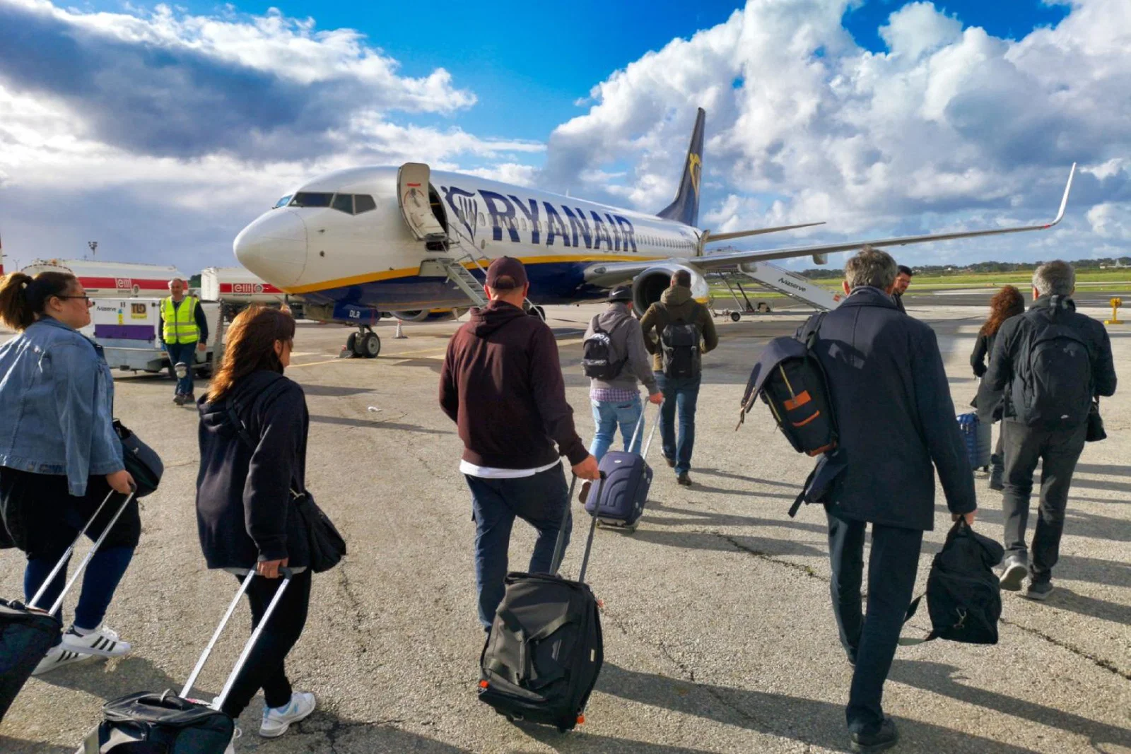 Ryanair passengers board an aircraft with their carry-on baggage
