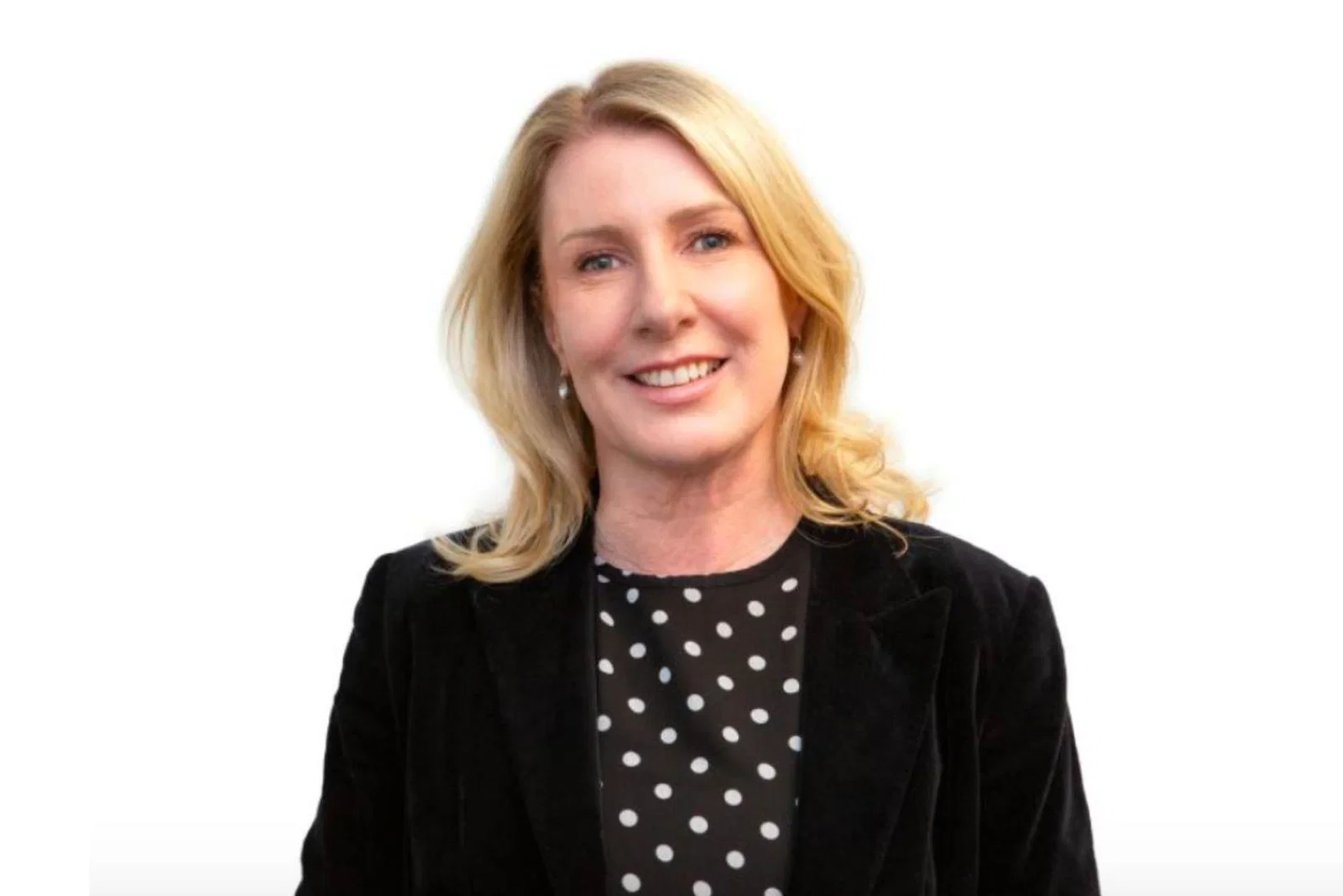 Blonde woman in black suit smiling