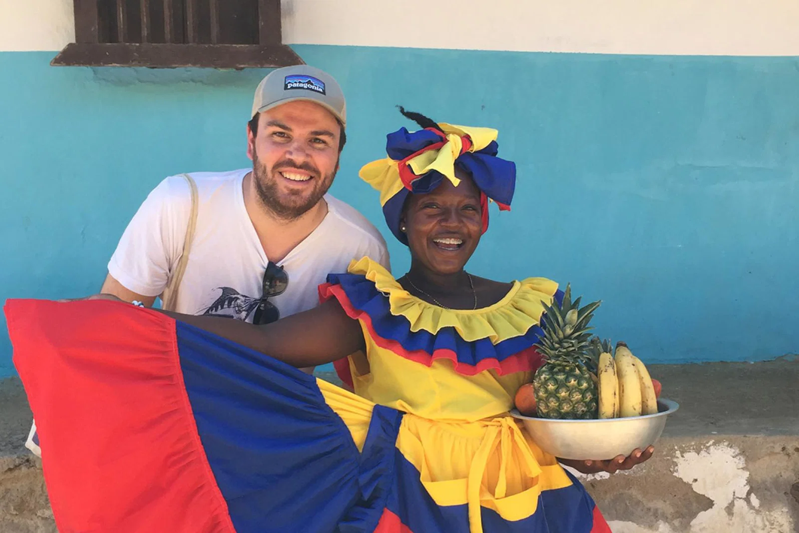 Charlie Thomas stands next to a Afro-Colombian woman wearing vibrant clothing