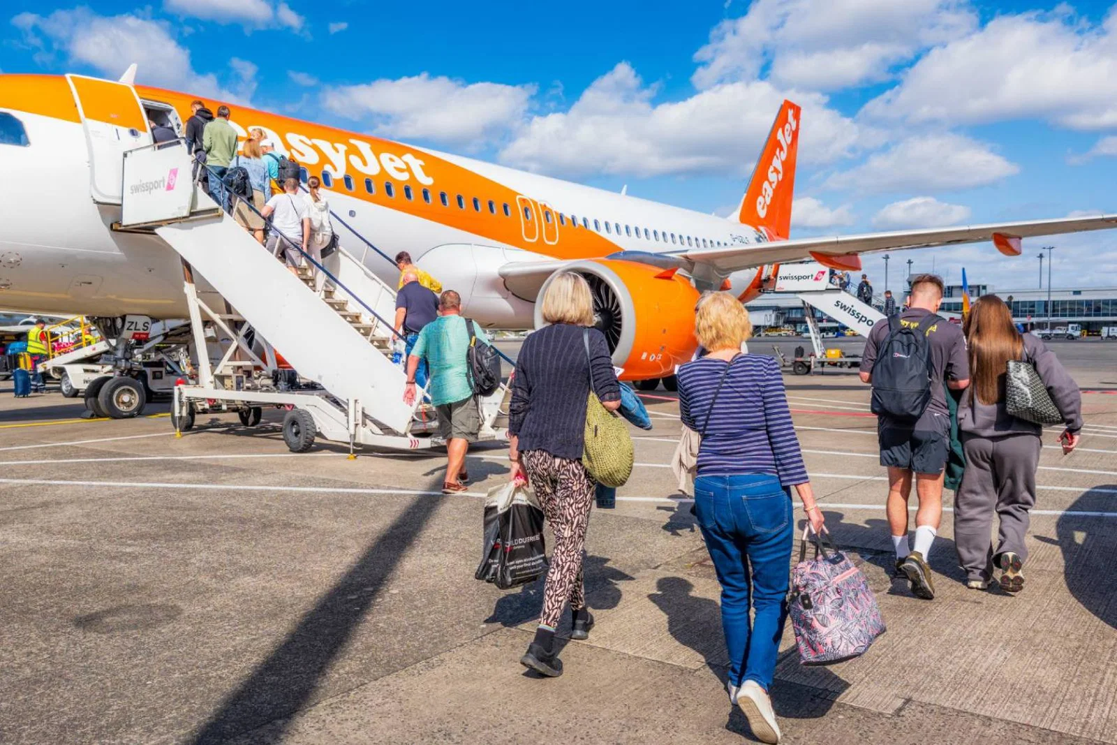Easyjet customers climbing onto plane on sunny day