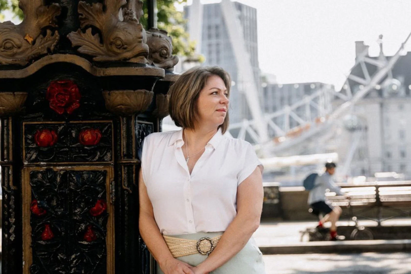 Brown haired woman outdoors in London, wearing white top and looking to the side