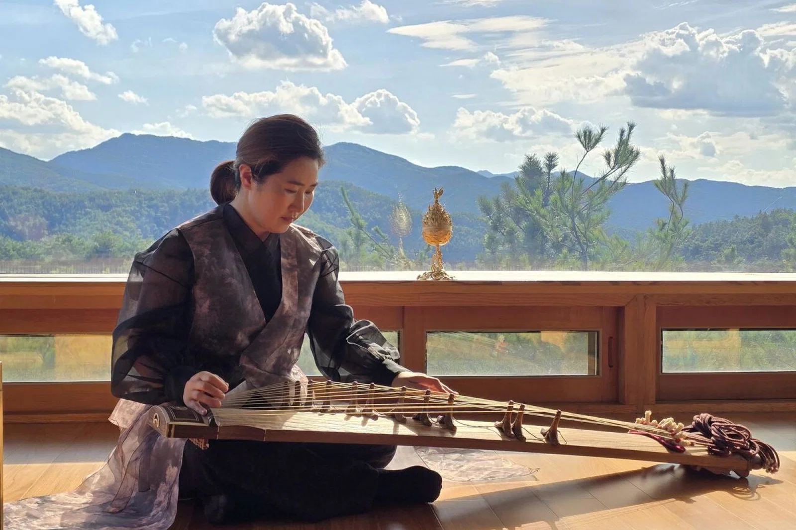A lady plays a gayageum – a traditional Korean stringed instrument