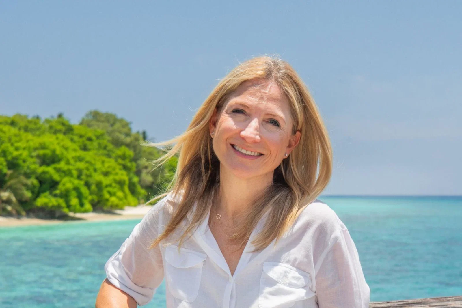 Blonde woman smiling with sea background 