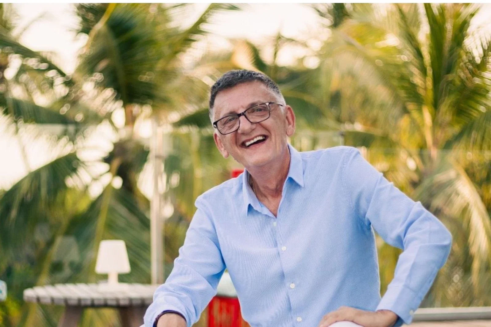 White man smiling with outdoors green background