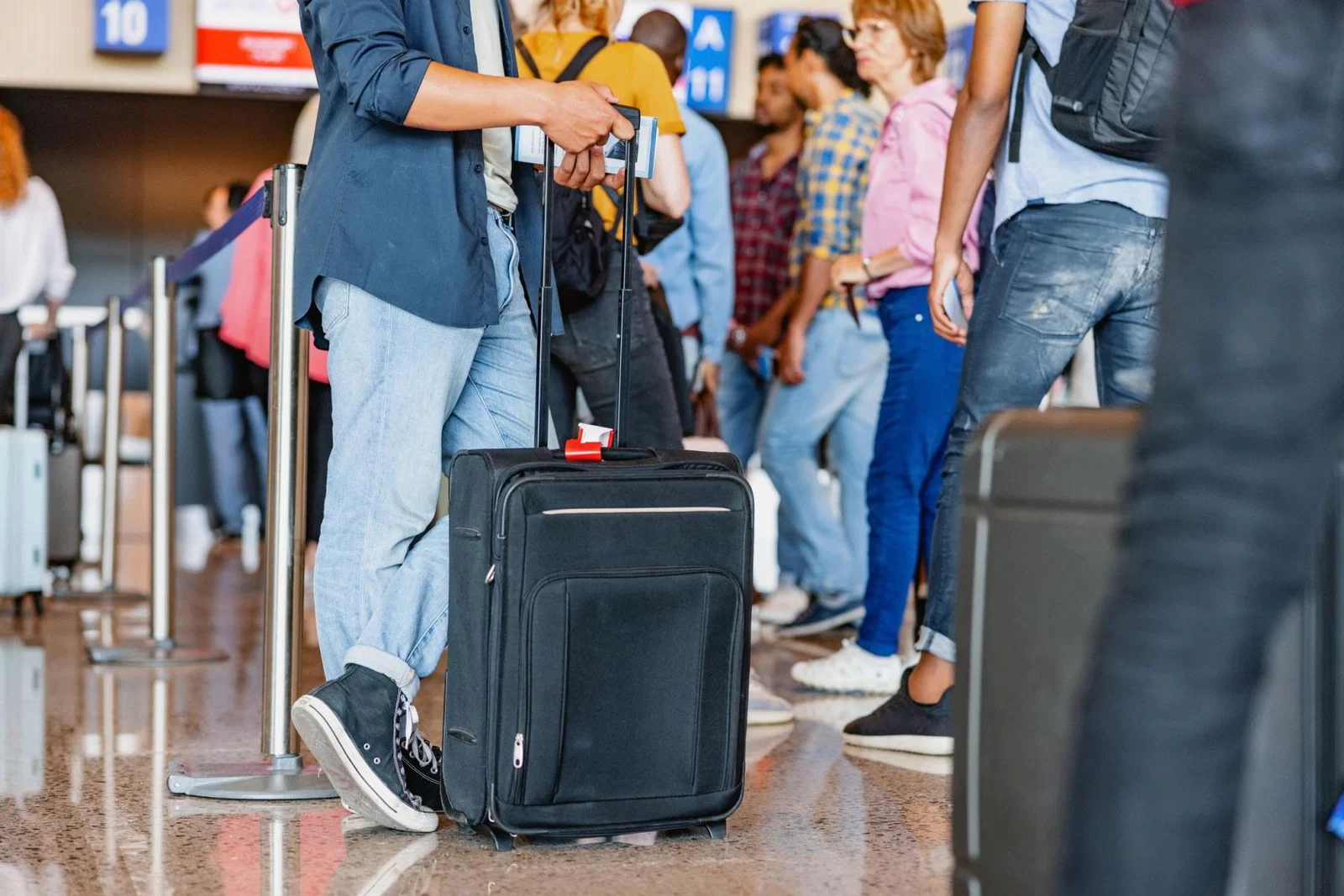 Passengers queue to check in at an unidentified airport
