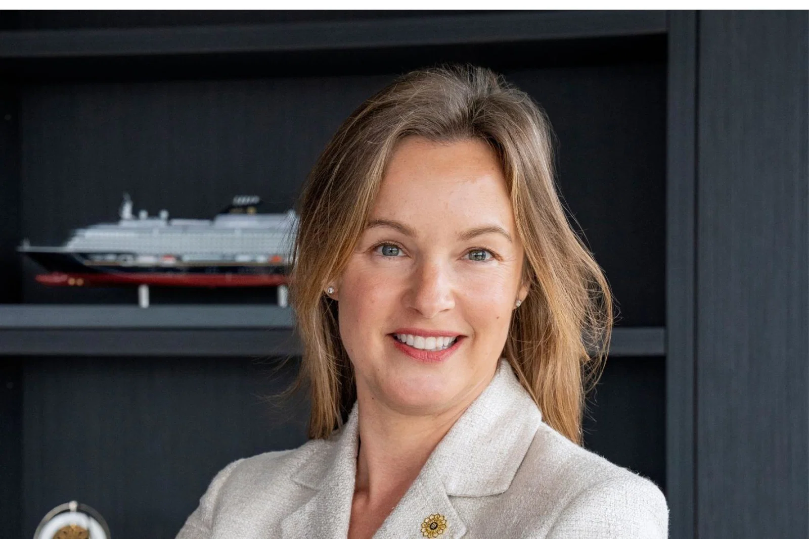 Professional headshot of smiling white woman with blonde-brown shoulder-length hair 