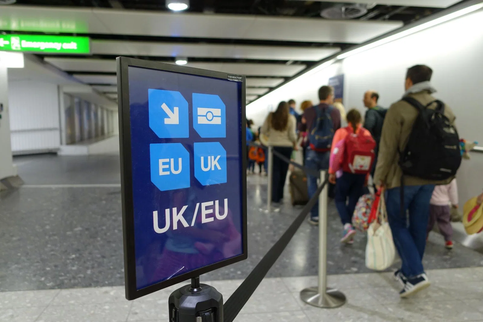 Passengers queue to clear border control at an airport