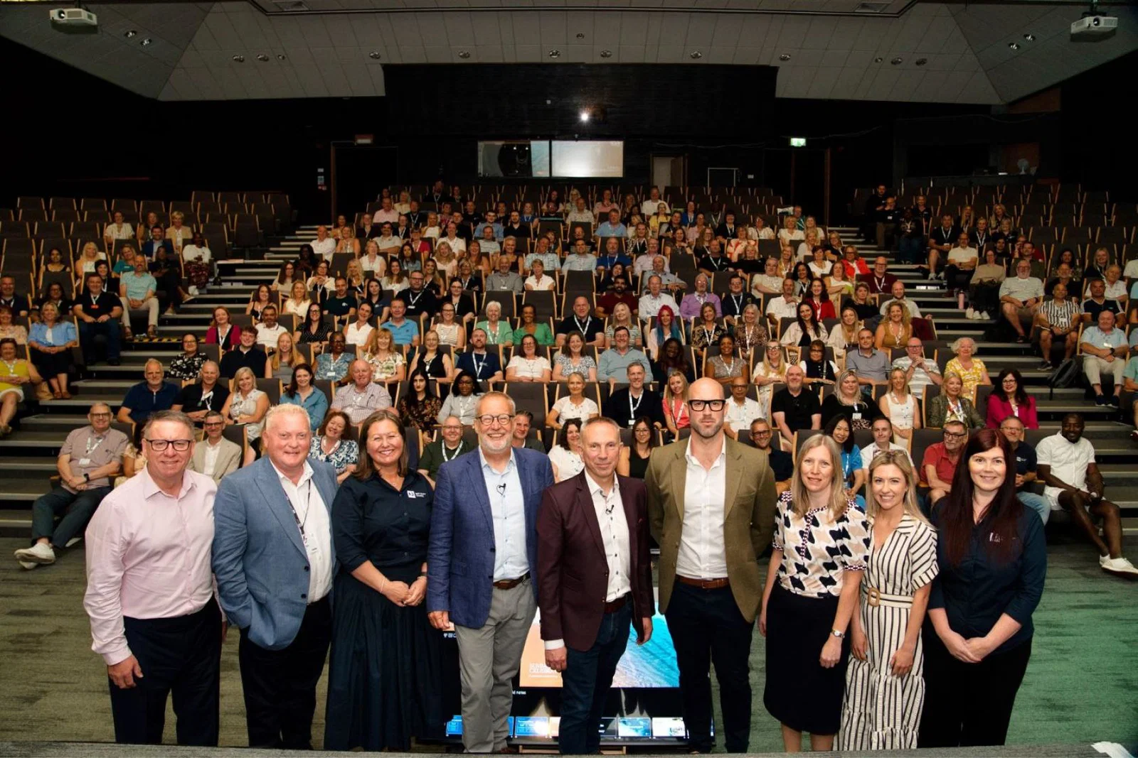 Large group of smiling people at work event 