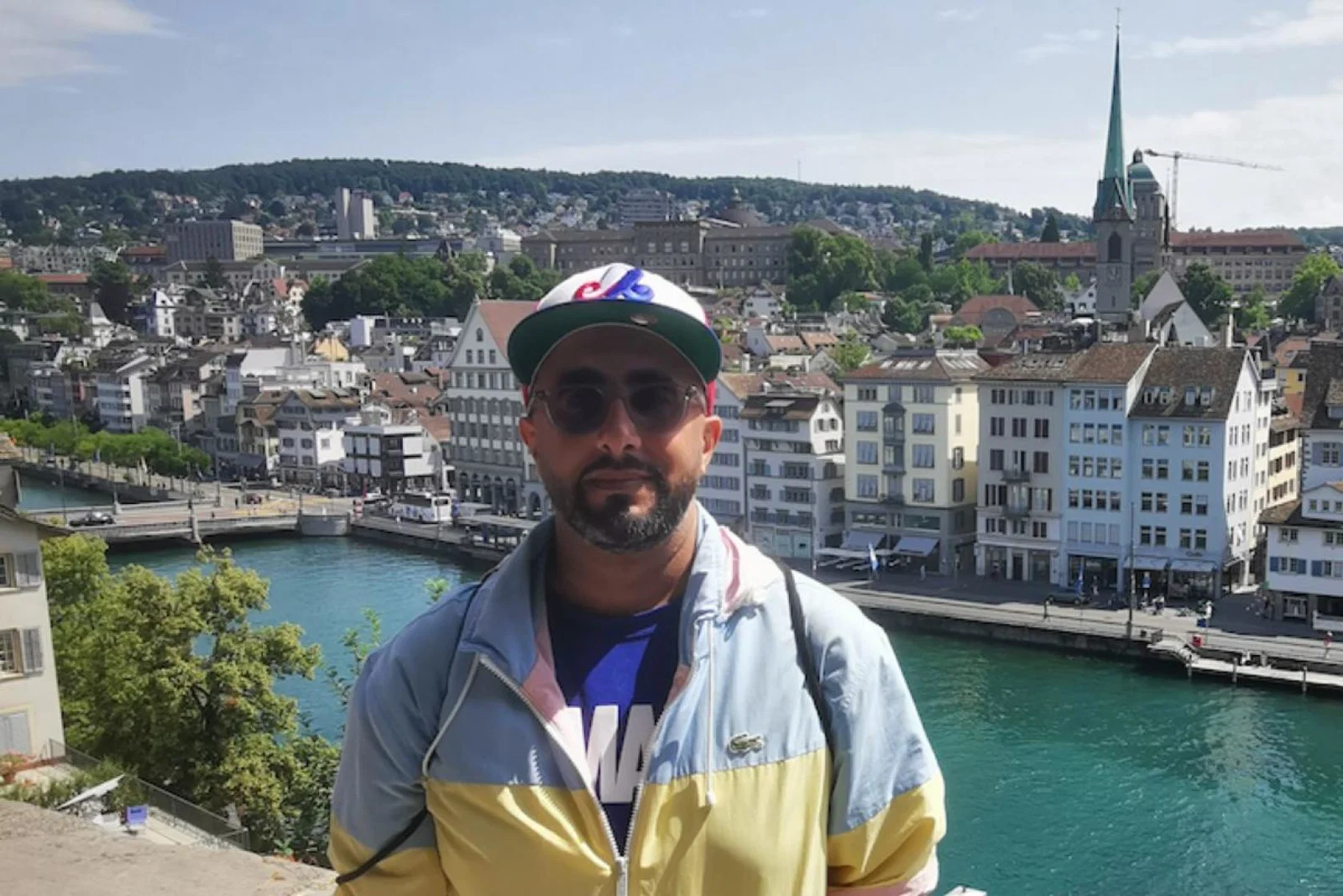 Man with sunglasses and hat in front of river in Europe