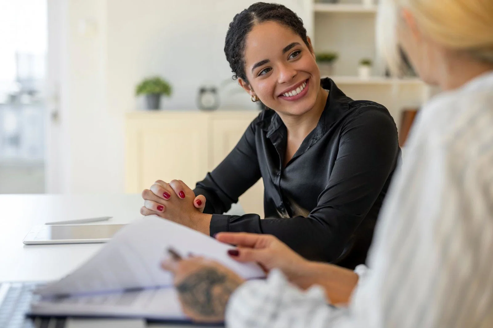 A job candidate pictured smiling with an HR manager