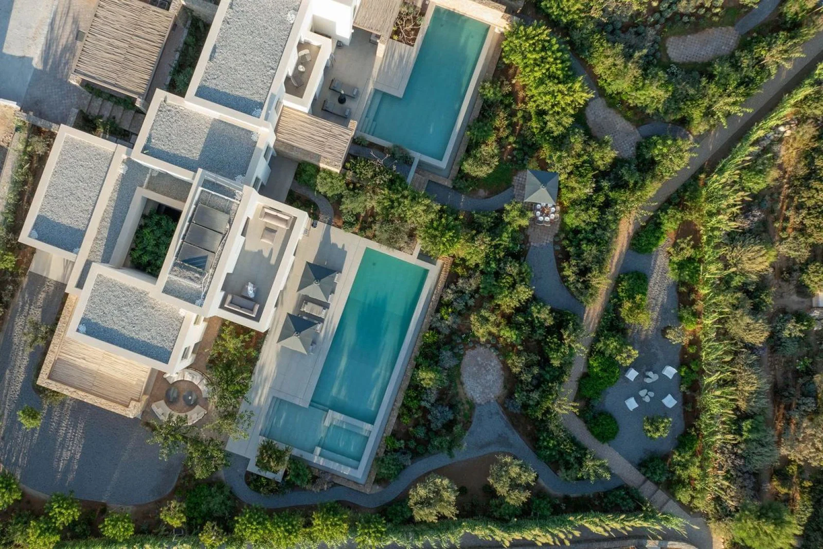 Votsalakia Seaside Escape birds eye view of the villas showcasing greenery surrounding the villa complex, pools and courtyards