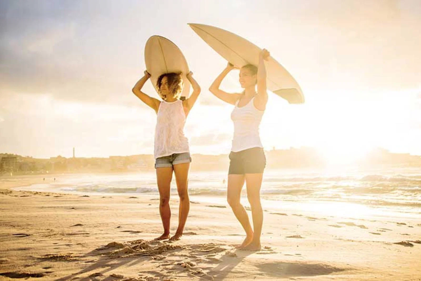 Female surfers on the beach iStock-485449959