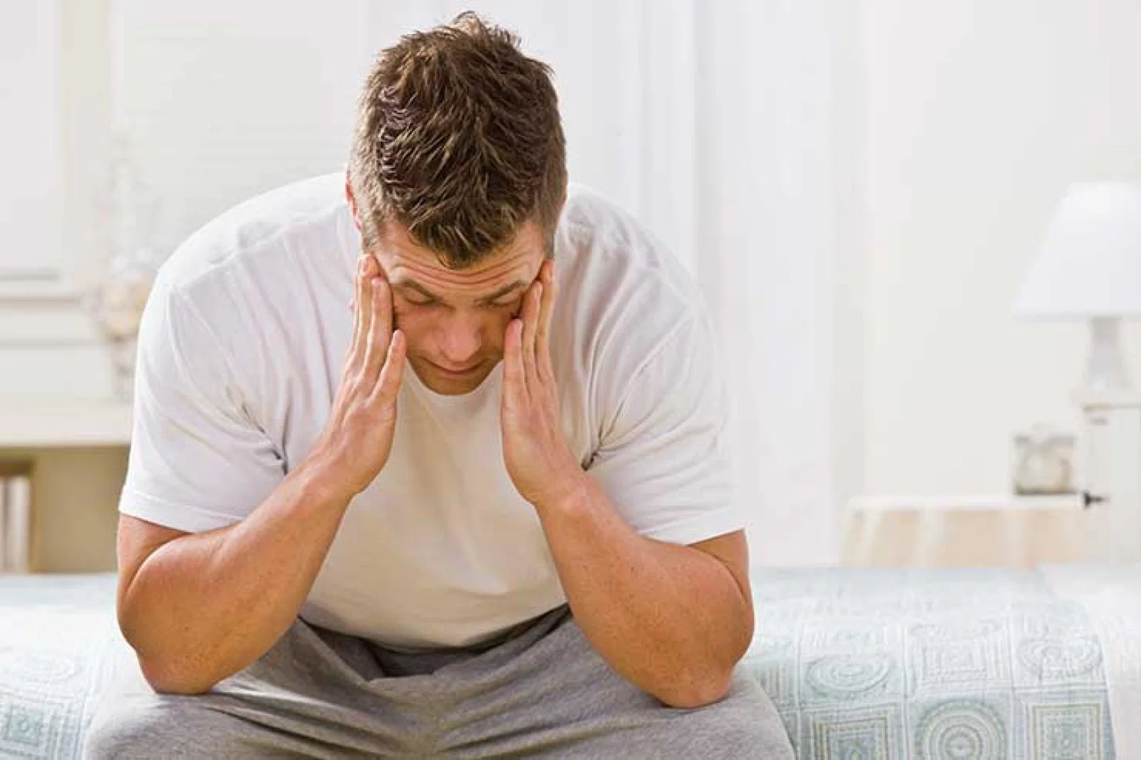 Sick man sitting on a bed