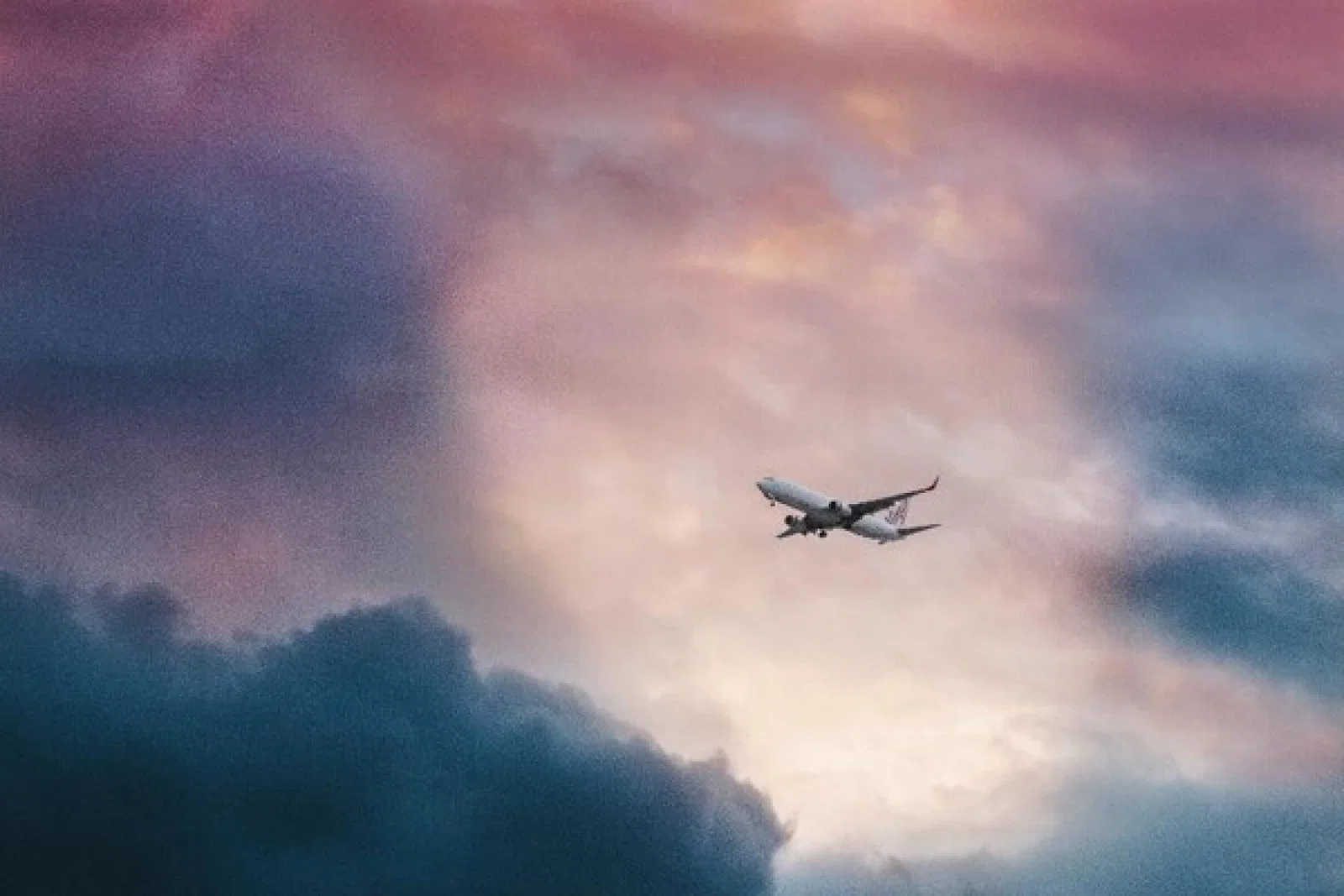 A plane emerges from stormy skies (Credit: Leio Mclaren/Unsplash)