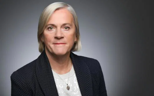 Headshot of middle-aged woman with short blonde hair wearing suit 
