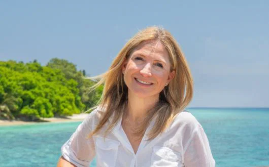 Blonde woman smiling with sea background 