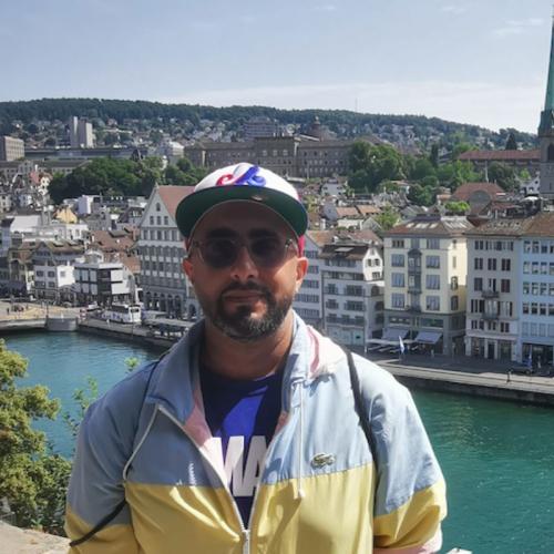 Man with sunglasses and hat in front of river in Europe