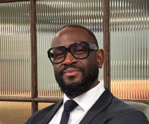 Man smiling, wearing glasses and suit 