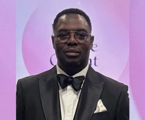 Black man wearing tuxedo, soft pink background 
