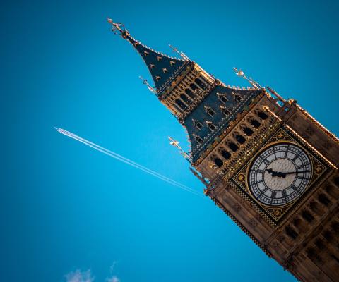 An aircraft flies past the Houses of Parliament in London