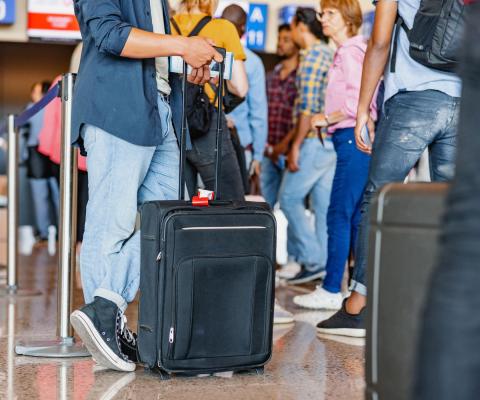 Passengers queue to check in at an unidentified airport