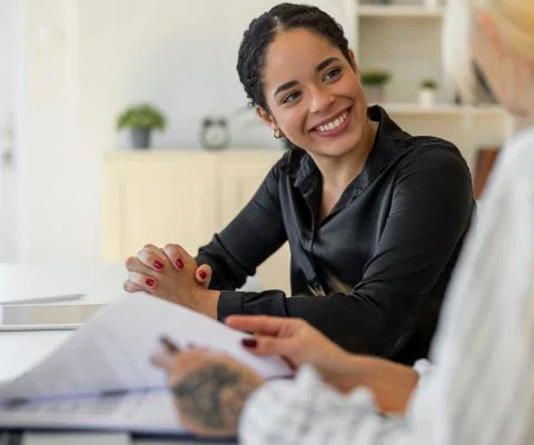A job candidate pictured smiling with an HR manager