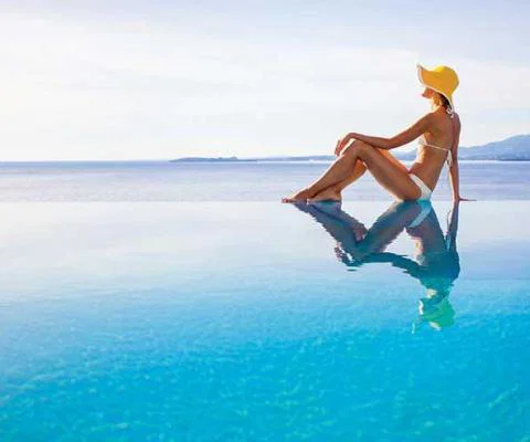 Lady sitting in infinity pool iStock-496069702