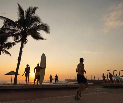 Silhouette of surfers running on the Durban beachfront
