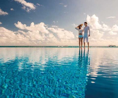 Couple standing by infinity pool