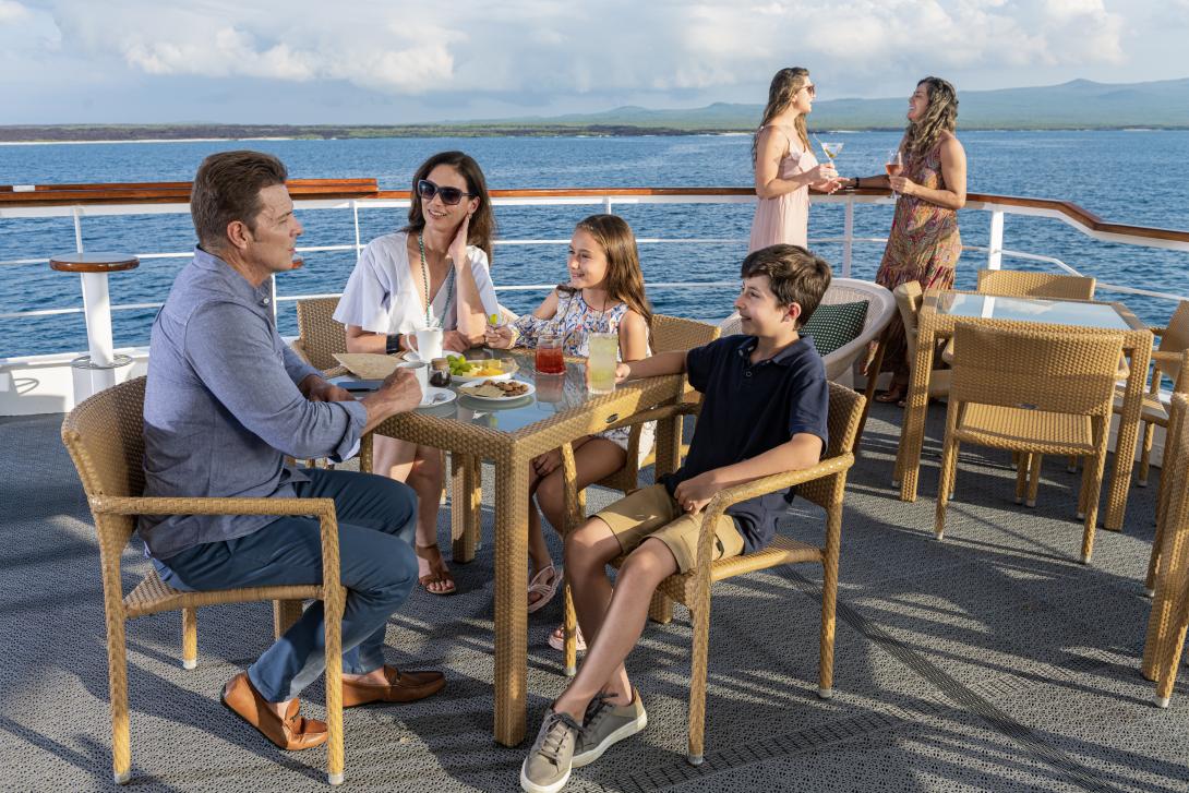 Family of four has lunch on open deck of ship