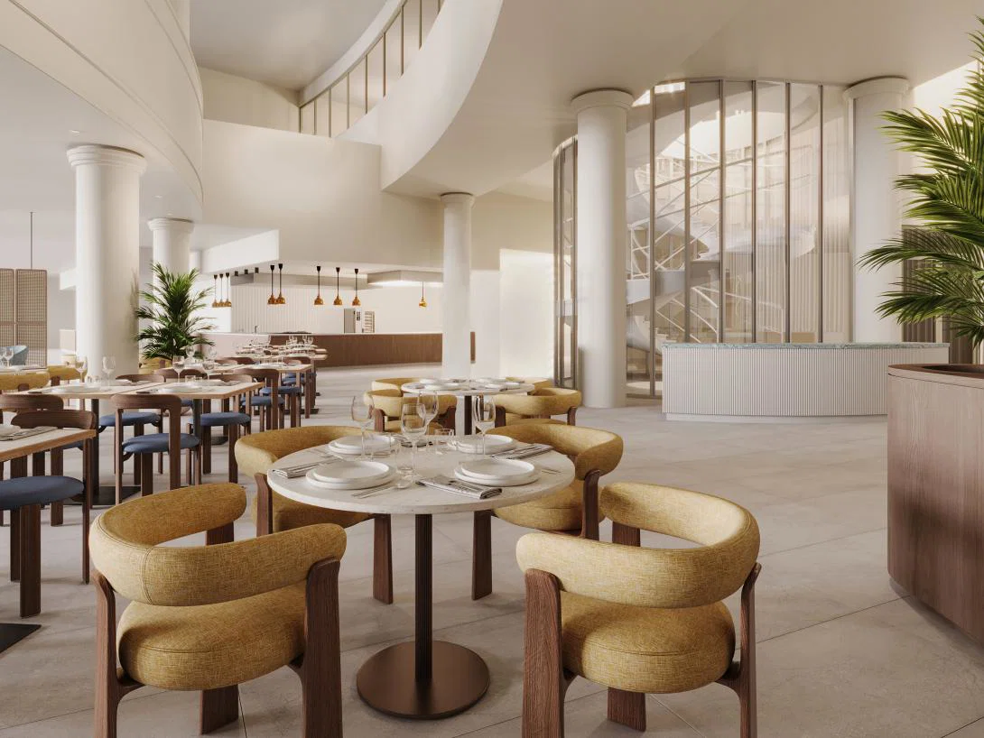 Large restaurant room in hotel with circular tables and stylish armchairs