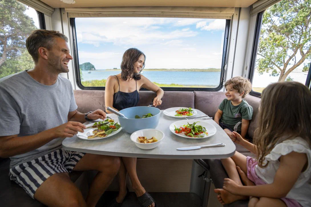 Family sitting around a table in a caravan