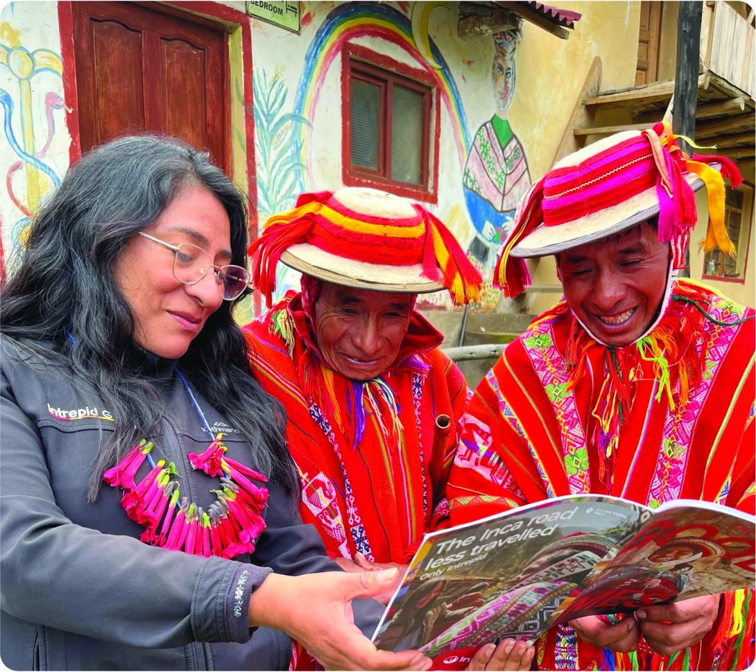 A guide and locals look at an Intrepid brochure