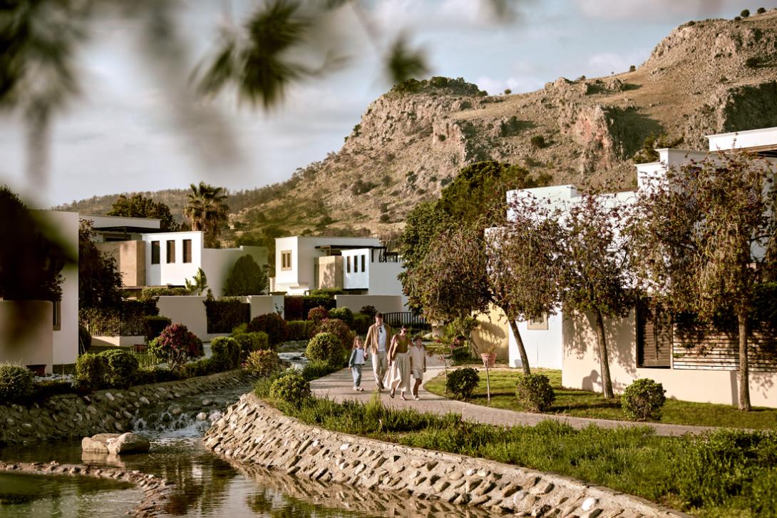 Family walking on path through Domes Resort in Rhodes