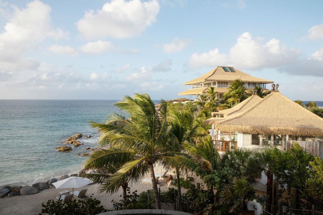 The Branson Beach Estate on Moskito Island Two thatched roofed villas overlooking a sandy, rocky beach