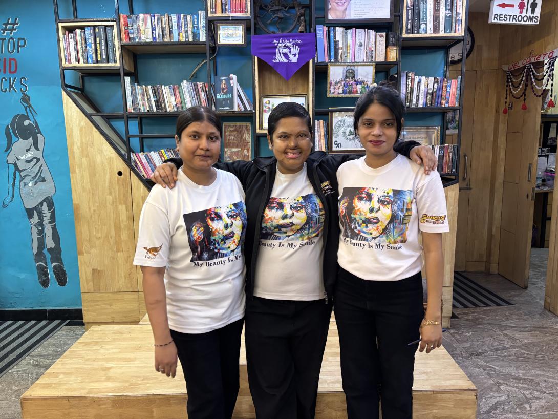 Credit: Jessica Reid Three smiling women who work at Sheroes Hangout wearing T-shirts saying 'My Beauty is my Smile'
