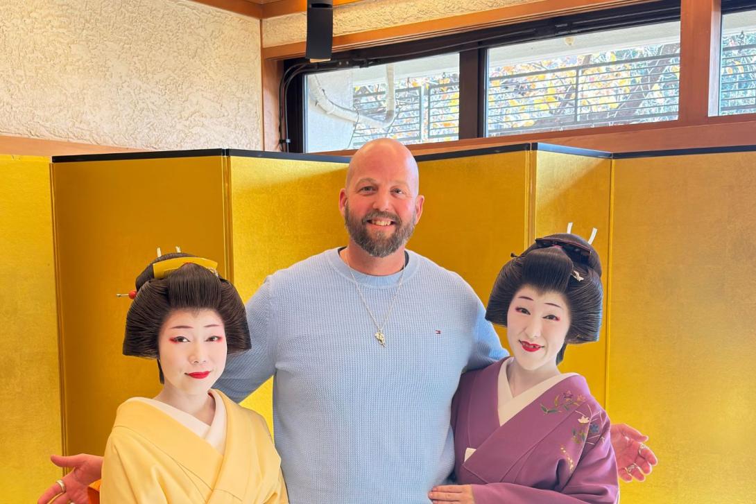 Man standing between two Geisha women