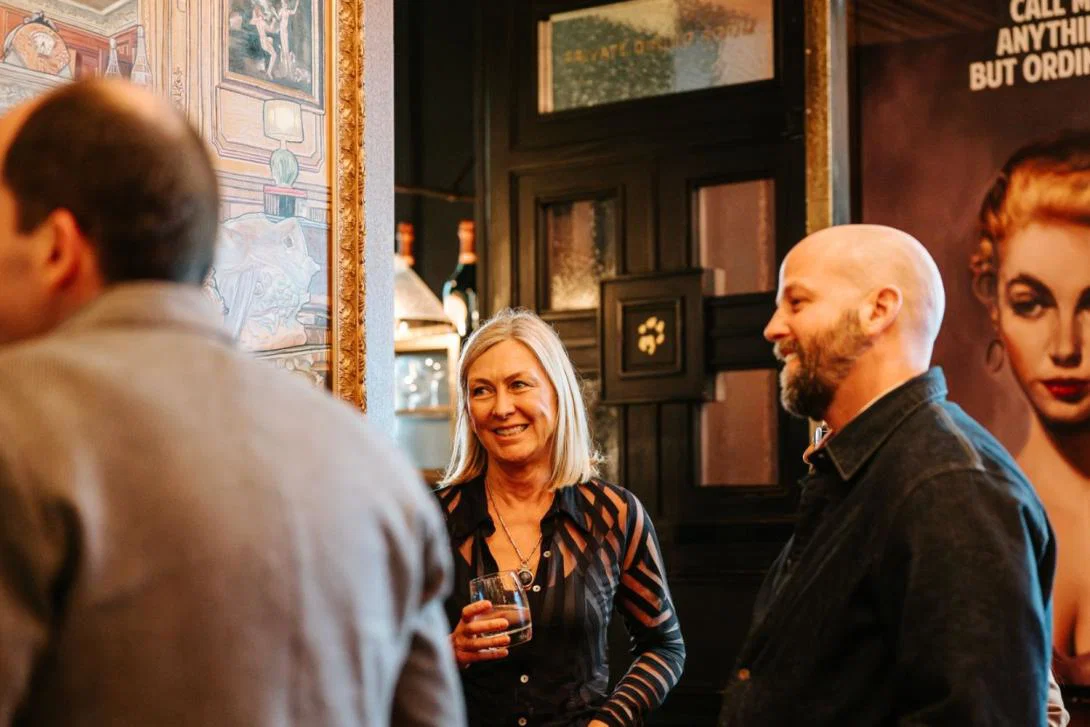 Woman with blonde hair and man with beard, both smiling