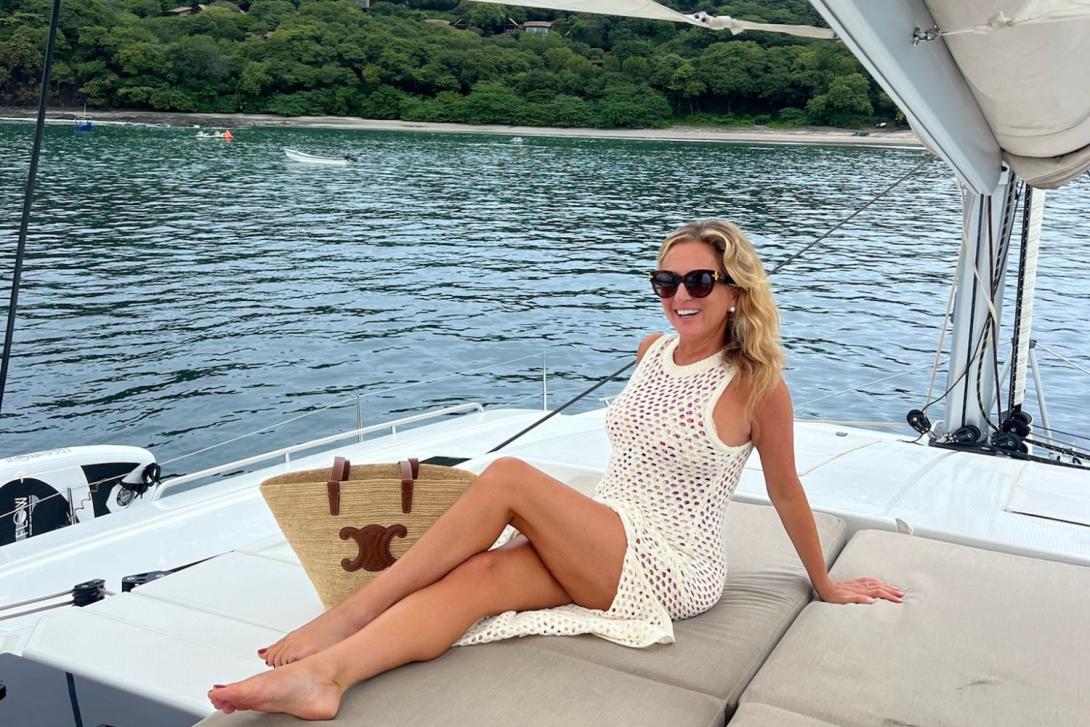 Woman with long blonde hair smiling on yacht