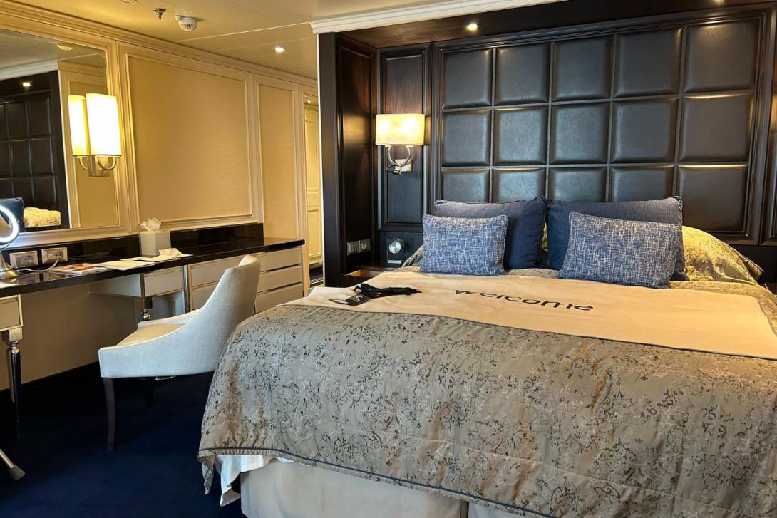 A luxury cabin suite on a ship with king-sized bed