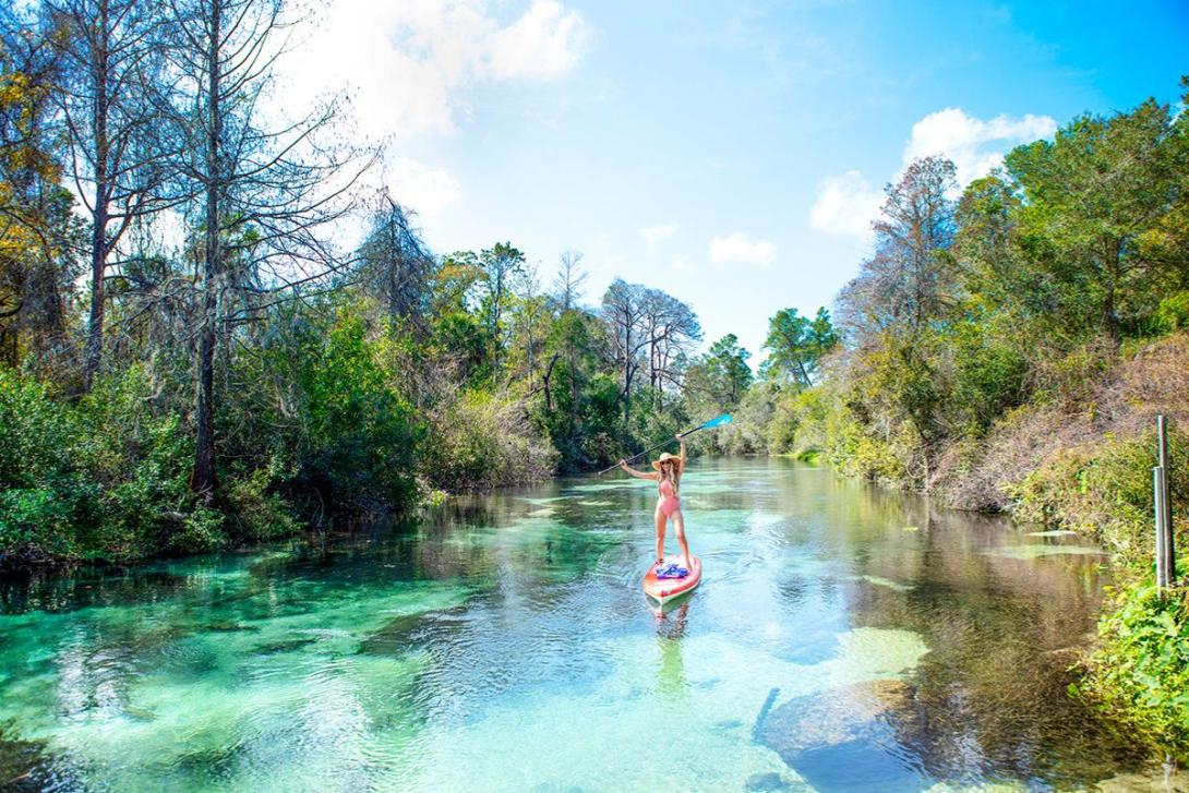 VISIT FLORIDA Woman on stand up paddle board on clear water