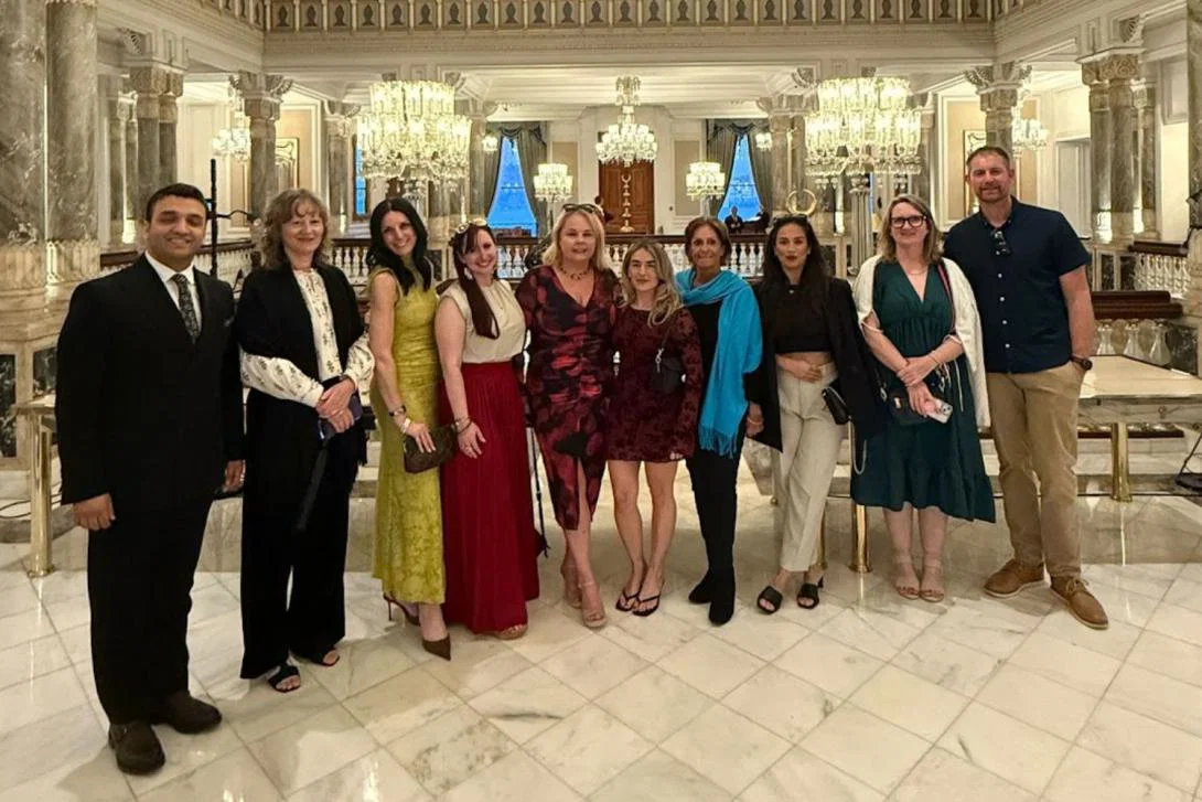 Group of people standing and smiling in fancy hotel