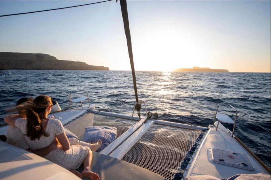 Couple on yacht, staring towards the sun