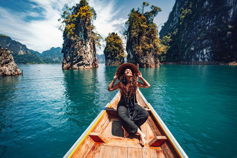 A female traveller in a wooden boat in Thailand