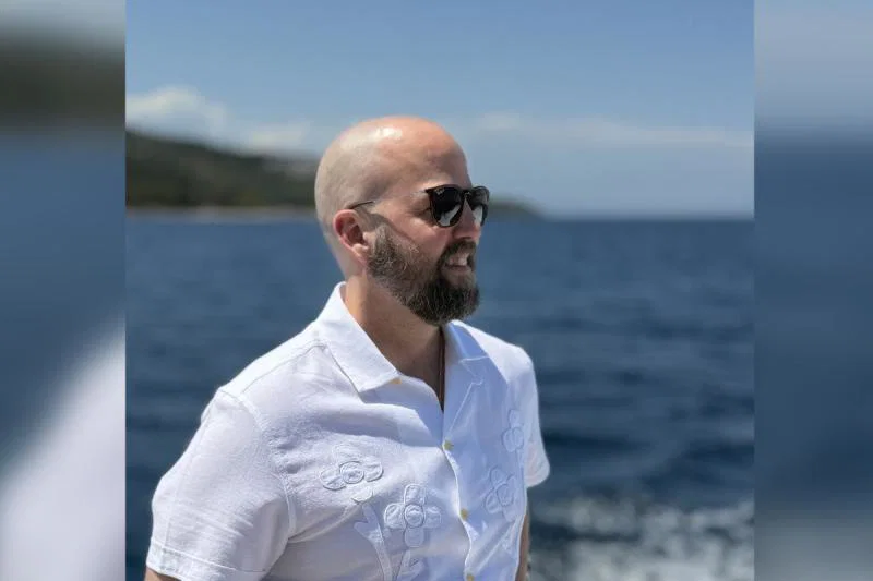Man with sunglasses looking out to sea 