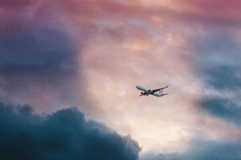 A plane emerges from stormy skies (Credit: Leio Mclaren/Unsplash)