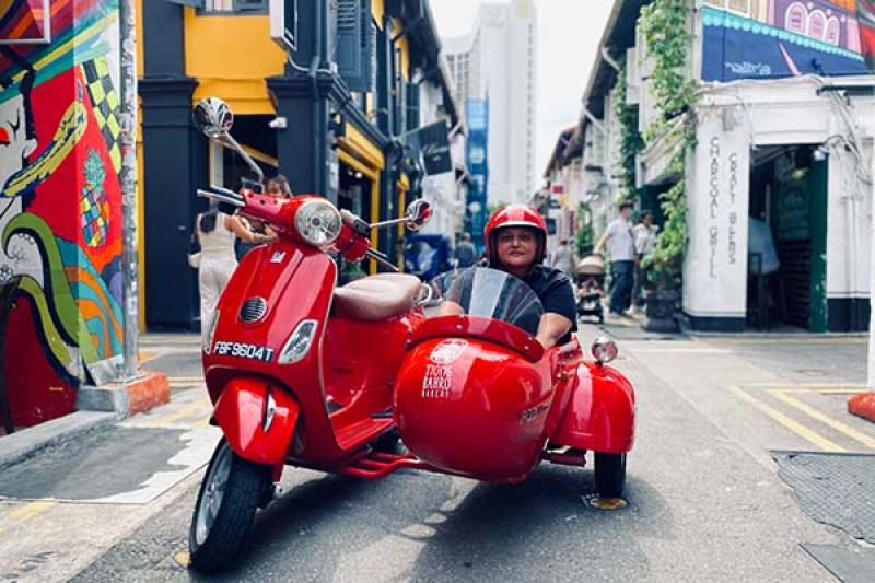 Carrier offers tours of Singapore in vintage Vespa sidecars, led by a local social enterprise business