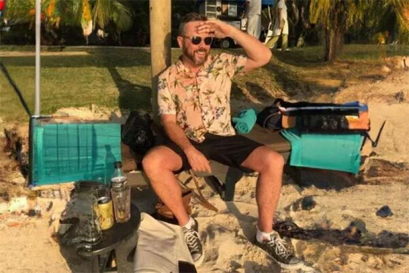 Matthew Ruth sitting on a beach